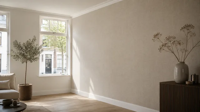 Woonkamer met een strak behangen wand in linnenstructuur naast wit geschilderde kozijnen
